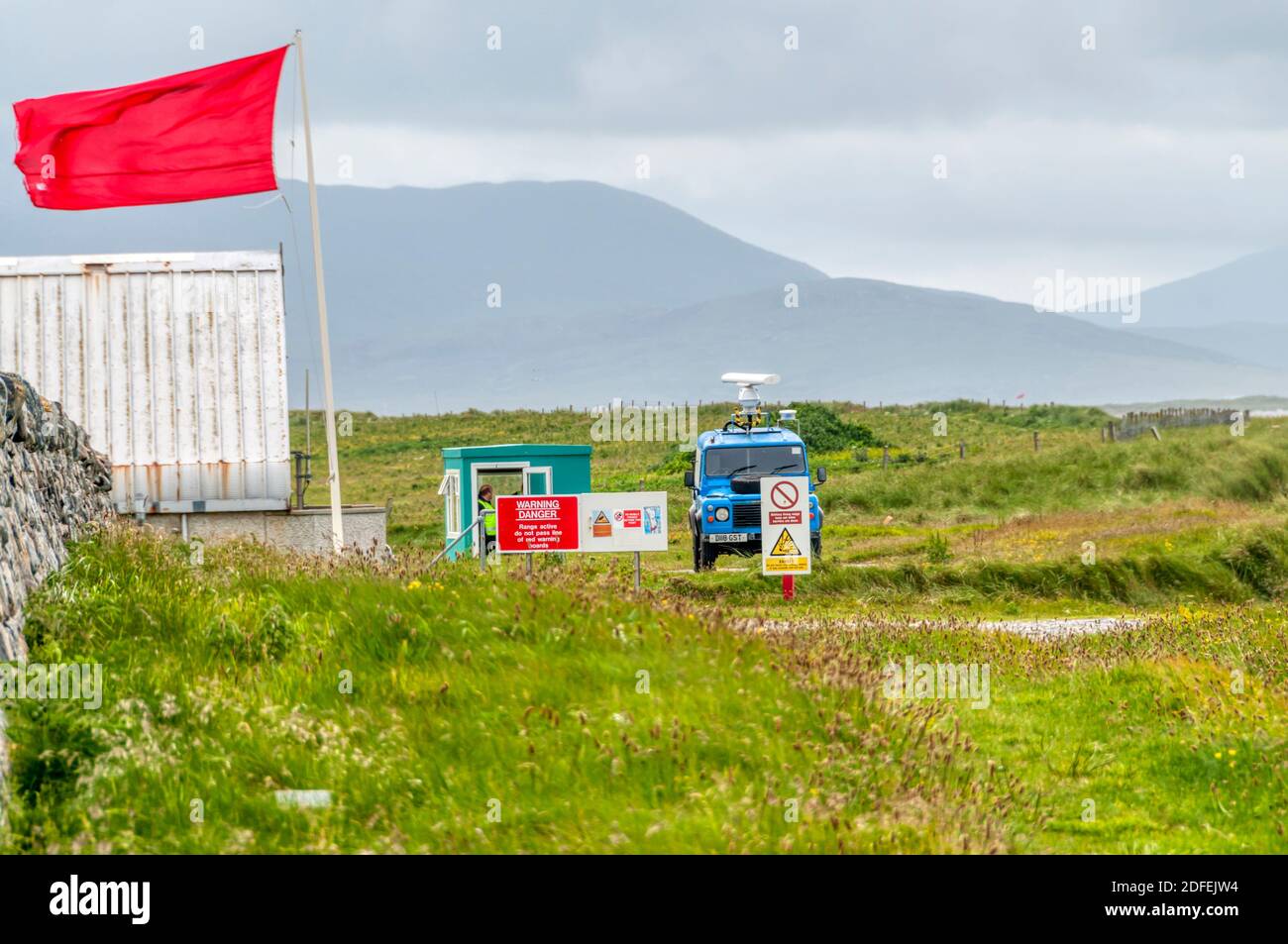 Red warning flag flying and warning notices at South Uist missile range. Stock Photo