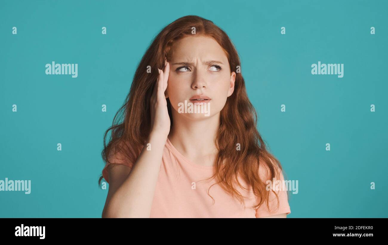 Portrait of tired girl showing headache on camera over colorful