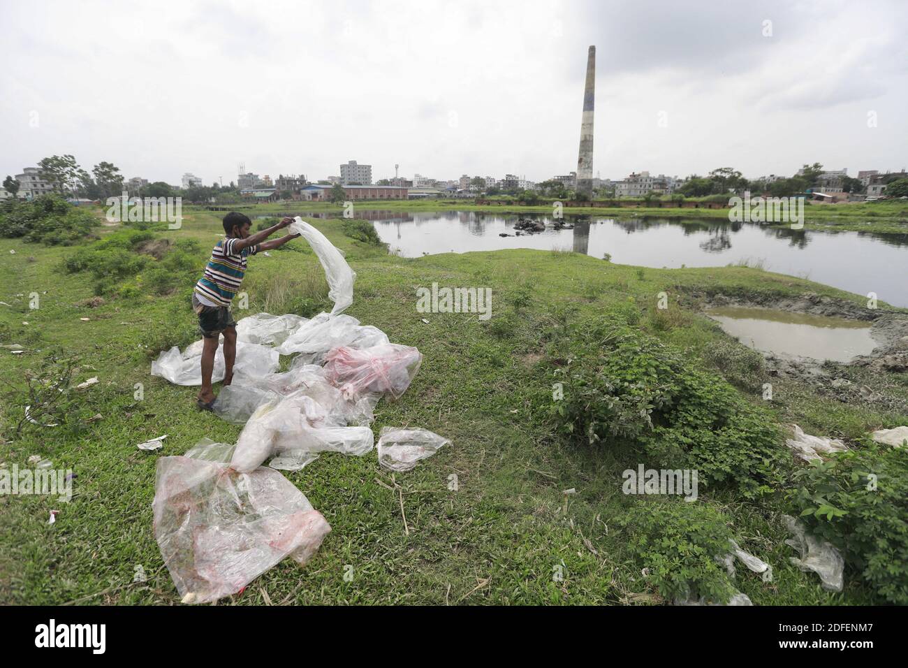 A Bangladeshi man dries plastic waste after wash them in the water of the Turag River in Tongi, near Dhaka, Bangladesh, July 9, 2020. Photo by Kanti Das Suvra/ABACAPRESS.COM Stock Photo