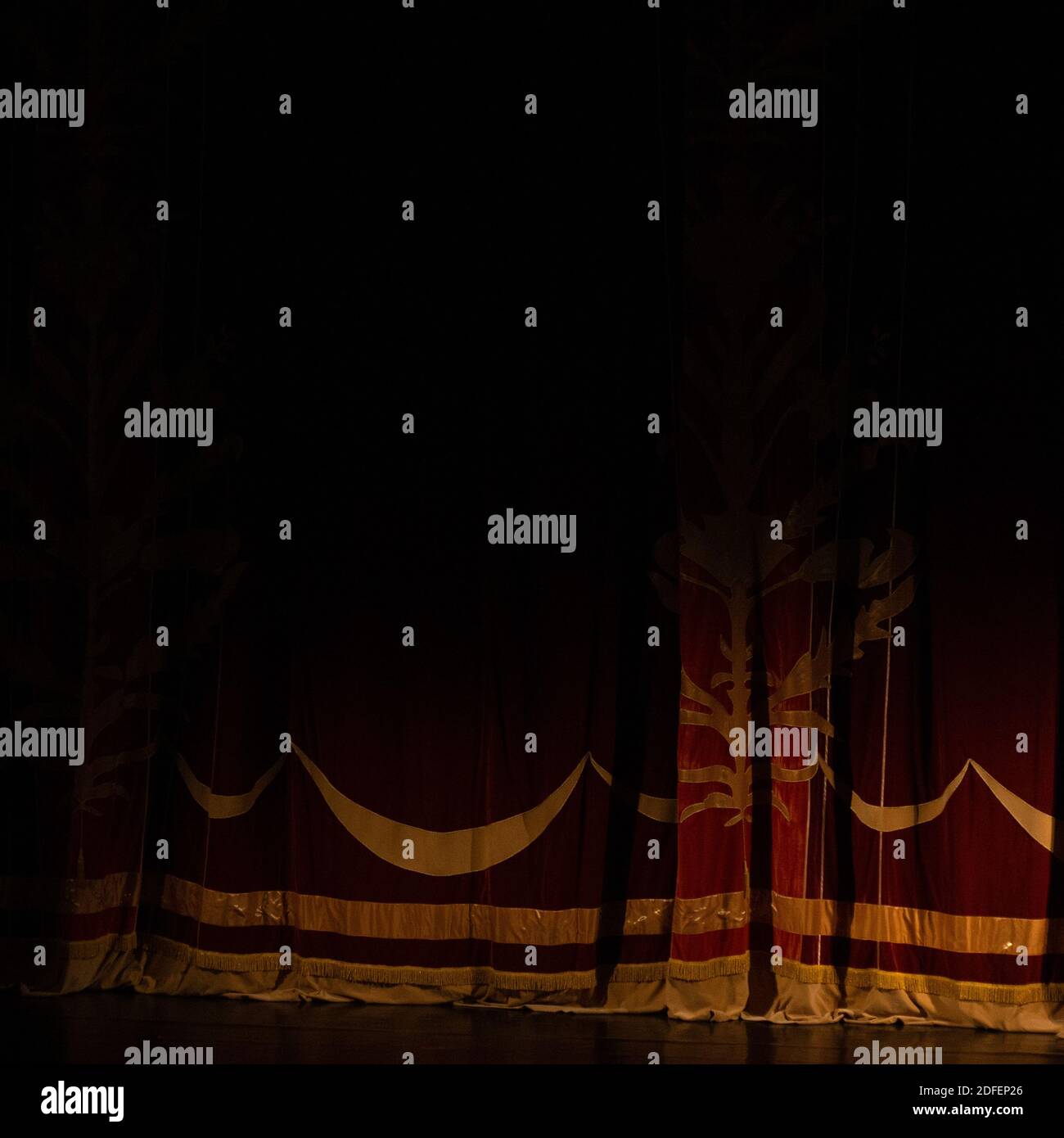 Theatrical dark red velvet curtain with golden fringe. Texture ...