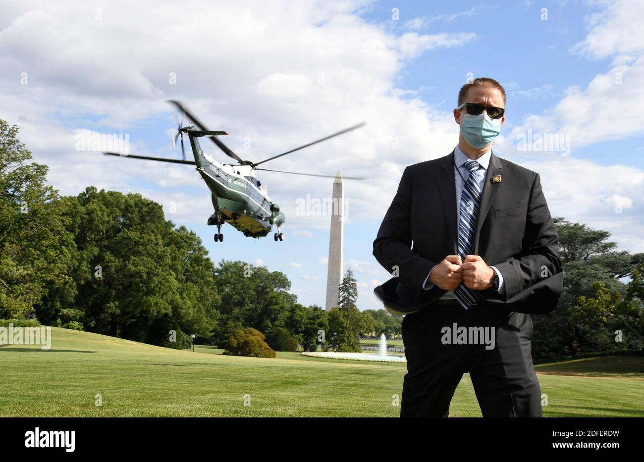 July 11, 2020 - Washington, DC - United States : A US Secret Service agent, wearing a mask to protect against COVID-19, stands on the South Lawn as Marine One lifts off with President Donald Trump, departing the White House for a visit to Walter Reed National Military Medical Center, in Bethesda Maryland. Photo by Mike Theiler/Pool/ABACAPRESS.COM Stock Photo