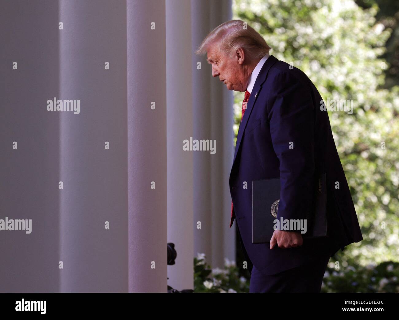 President Donald J. Trump walks into the Rose Garden as he holds a ...