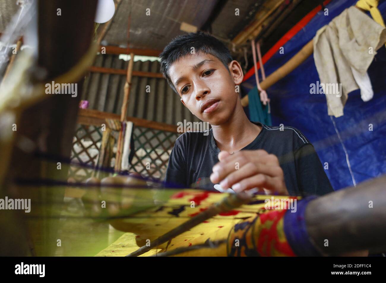 Nur Alam, 13, weaves Jamdani saree on a traditional wooden hand weaving