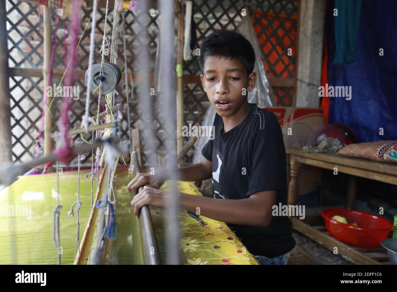 Nur Alam, 13, weaves Jamdani saree on a traditional wooden hand weaving