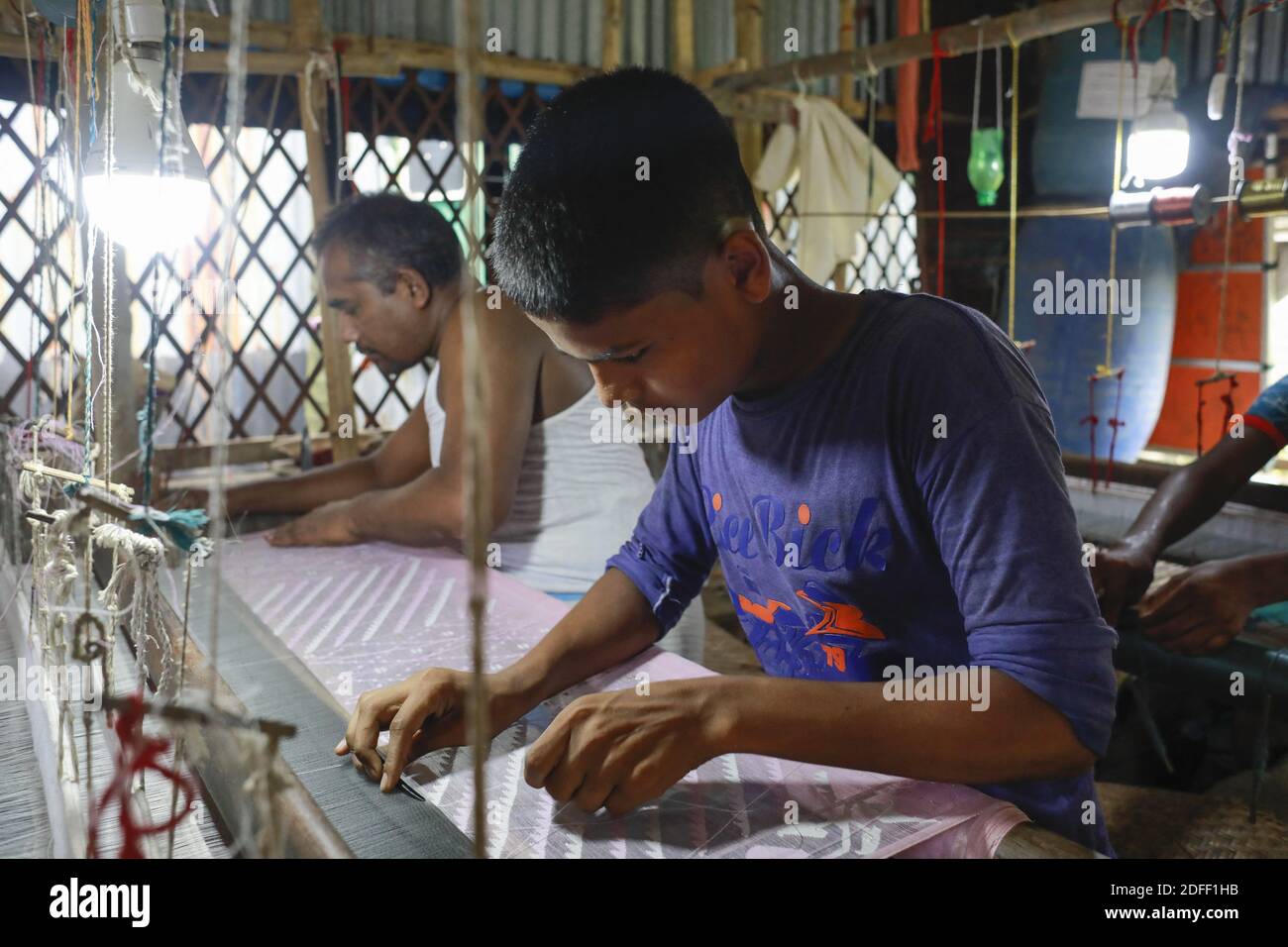 Handloom weaver weaves Jamdani saree on a traditional wooden hand