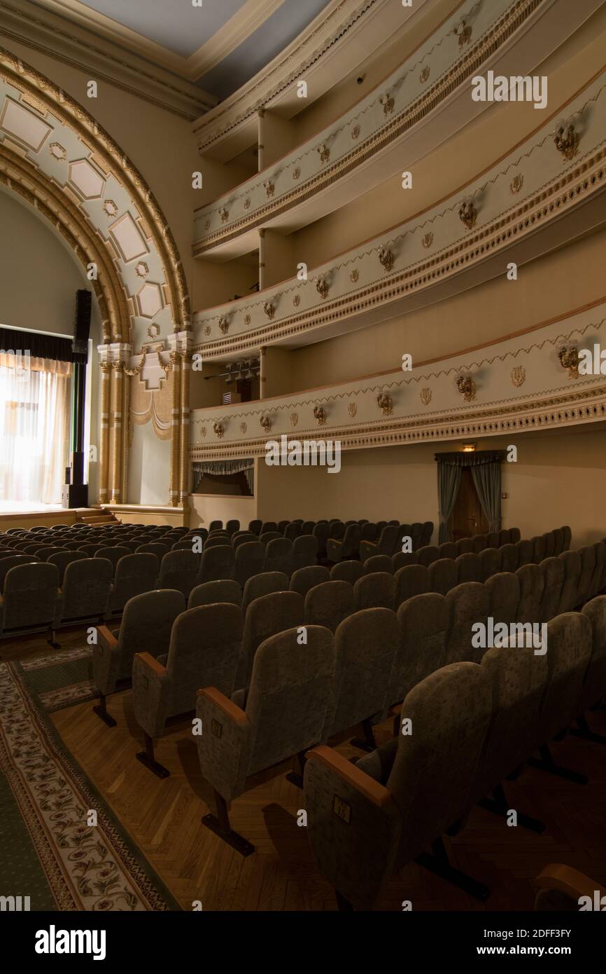 Interior of a concert hall or theater with light and velvet chairs ...