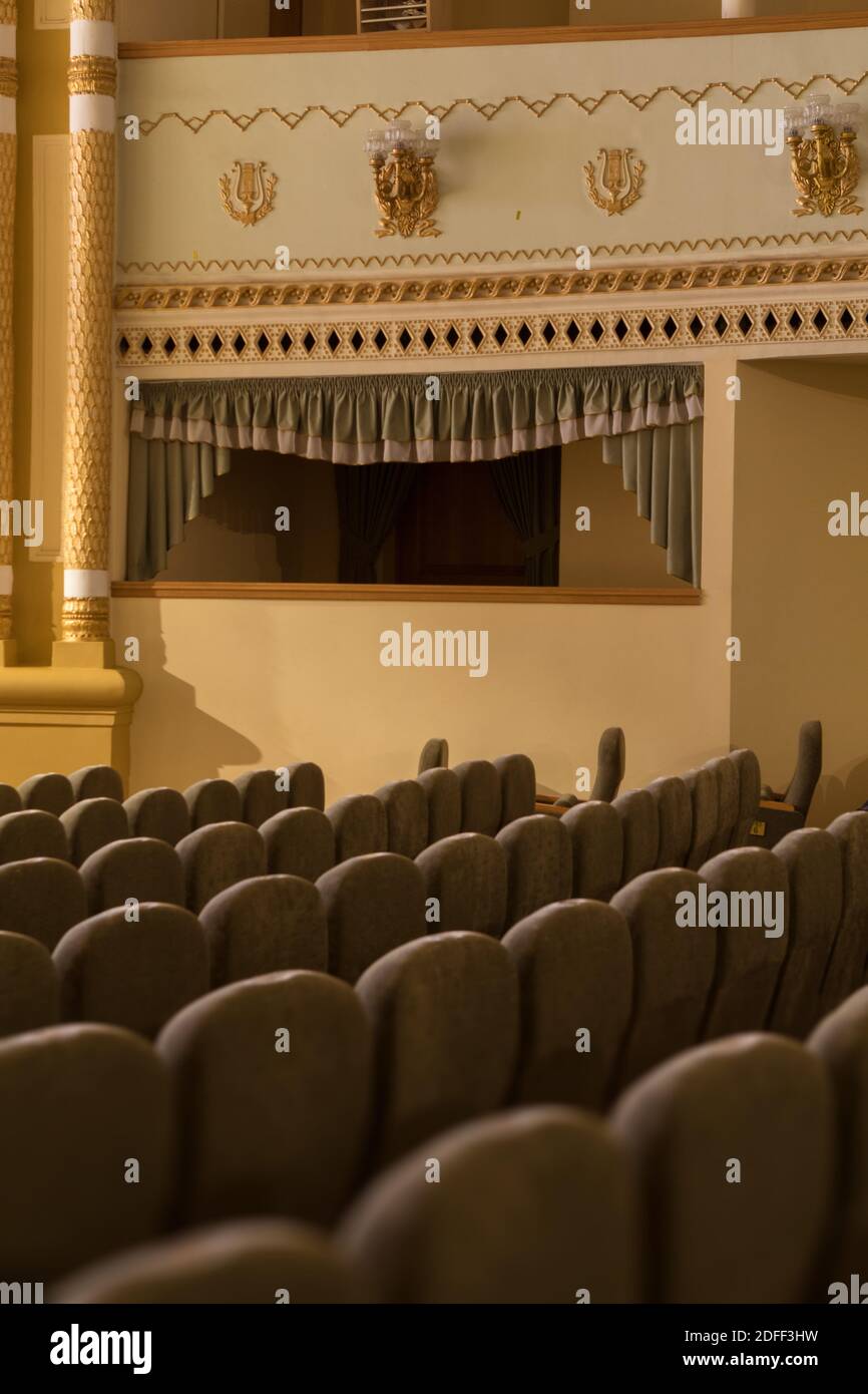 Interior of a concert hall or theater with light and velvet chairs ...