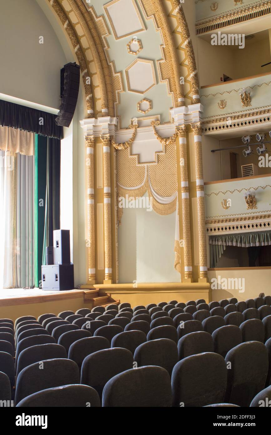 Interior of a concert hall or theater with light and velvet chairs ...
