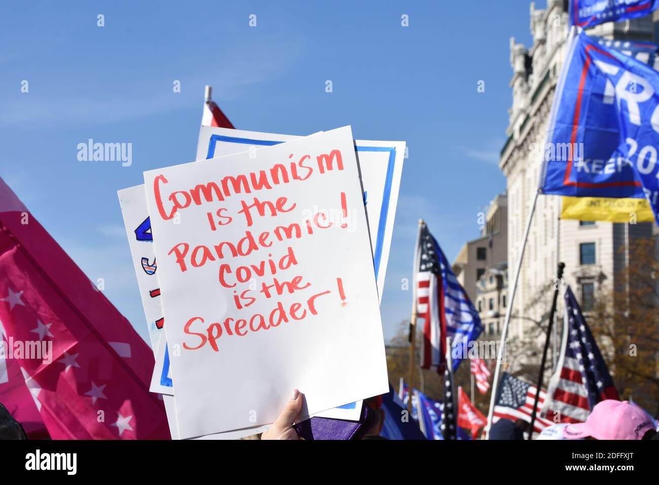 Washington DC. November 14, 2020. Million Maga March. Political sign said “Communism is the pandemic! Covid is the spreader!” at Freedom plaza. Stock Photo