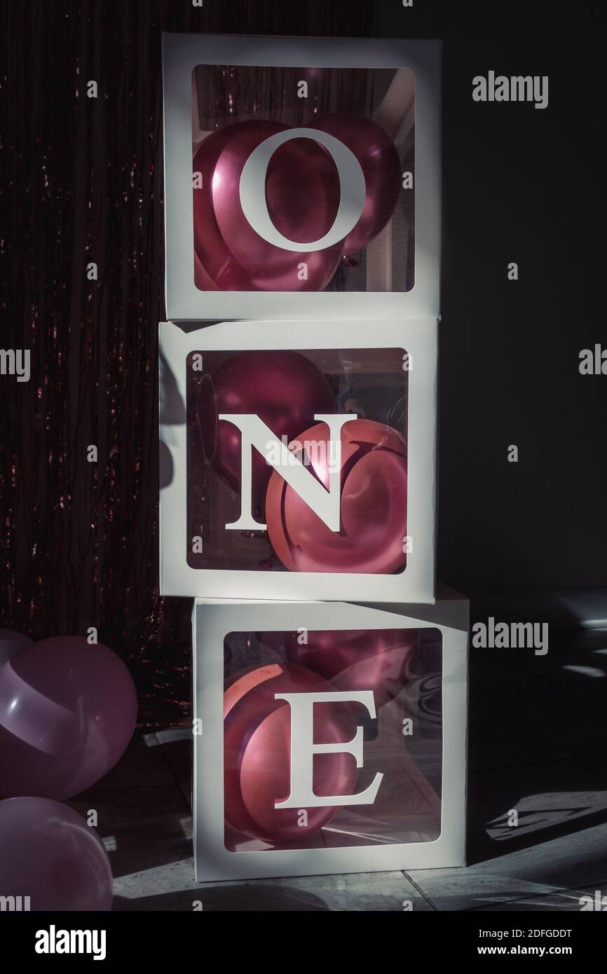 a vertical shot of transparent containers with balloons stack on each ...