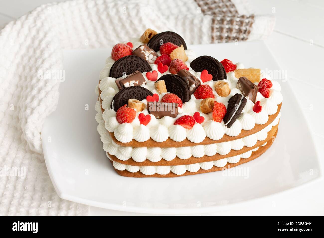 Heart-shaped cake with ricotta and whipped cream, garnished with chocolate,  waffles, cookies and strawberries Stock Photo - Alamy