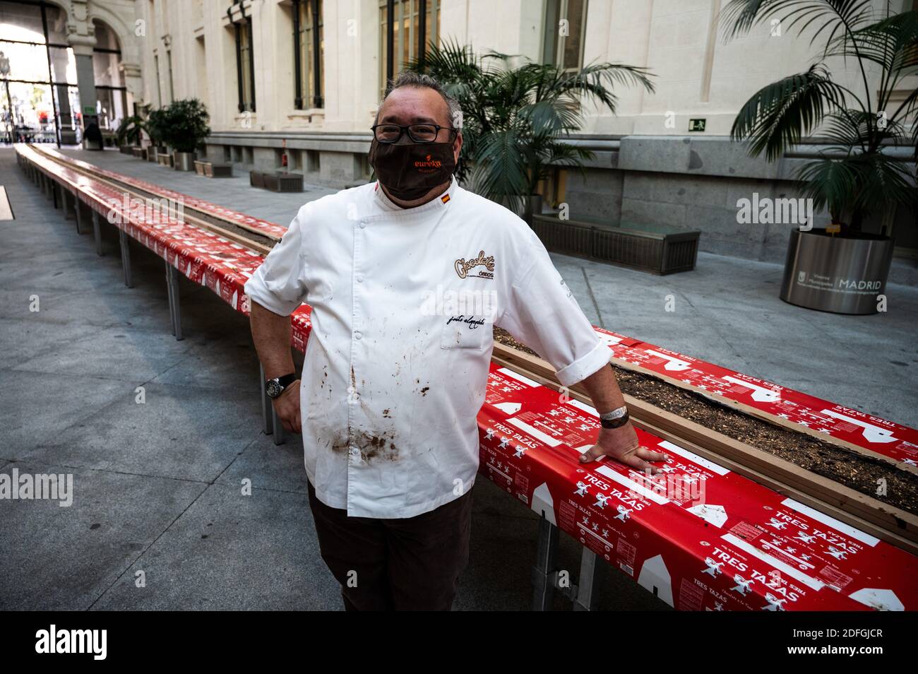 Madrid, Spain. 04th Dec, 2020. The master chocolatier Justo Almendrote, of Spain's oldest chocolate factory La Colonial, posing with the world's largest chocolate almond nougat, known in Spanish as 'Turron', with 50 meter of length (164 foot). Two hundred kilos of chocolate, 100 liters of cream, 90 kilos of almonds and 9 hours to make it, which will be cut into thousands of tablets, will be sold to the public and the proceeds will go to social purposes of the Fundacion Esperanza y Alegria. 'Turron' is a typical Christmas sweet very consumed in Spain. Credit: Marcos del Mazo/Alamy Live News Stock Photo