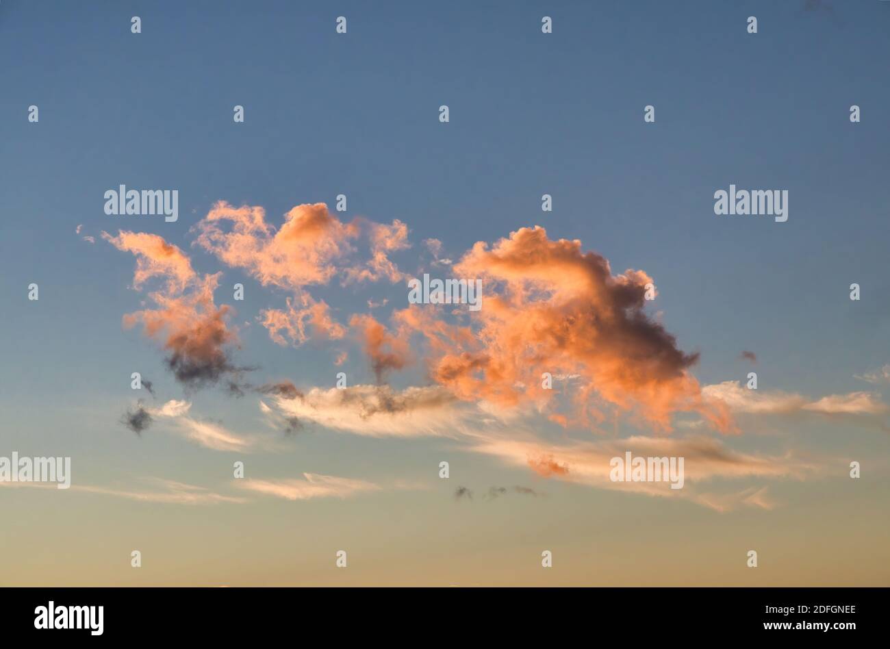 Cloudsscape with puffy golden clouds against a deep blue sky. Stock Photo