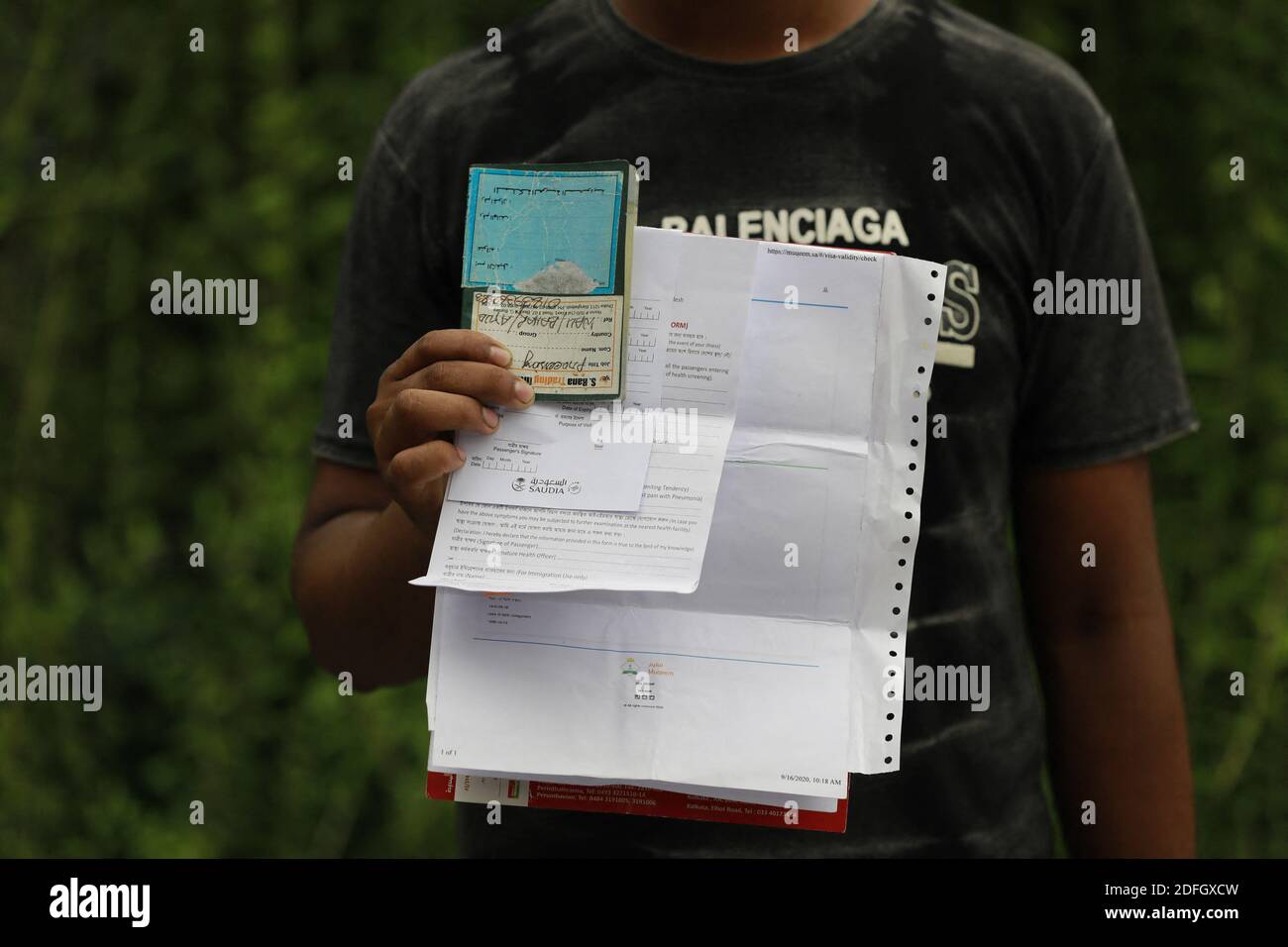 A Bangladeshi migrant worker shows his return ticket to go back to Saudi Arabia after, in Dhaka, Bangladesh, on September 24, 2020. Saudia has begun selling tickets in Dhaka, ending days of wait and demonstration by stranded Bangladeshi migrant workers. At least 30,000 Bangladeshi expatriate workers are waiting to return to their workplaces in Saudi Arabia, said an official of Saudi Airlines. More than 2 million Bangladeshi expatriates work in Saudi Arabia. Nearly half of the $18.2 billion remittances received by Bangladesh in the 2019-20 fiscal years came from the Middle-Eastern kingdom. Phot Stock Photo