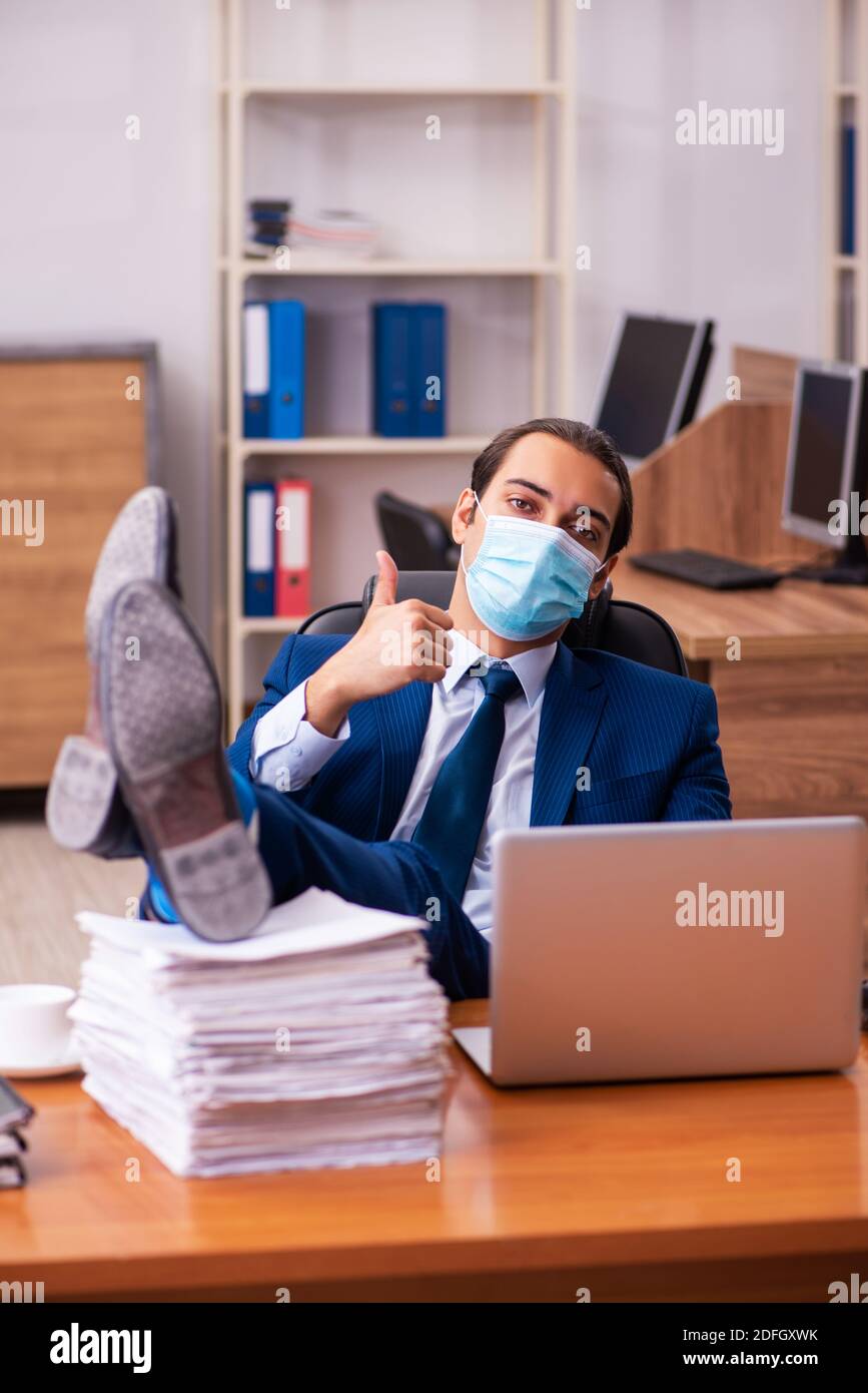 Young employee working in the office wearing mask Stock Photo - Alamy