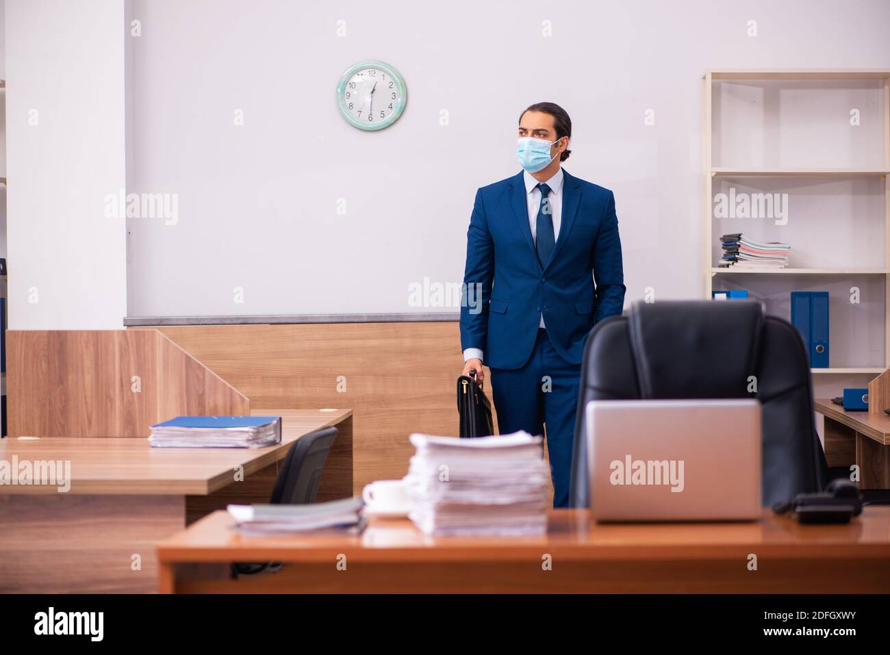 Young employee working in the office wearing mask Stock Photo - Alamy