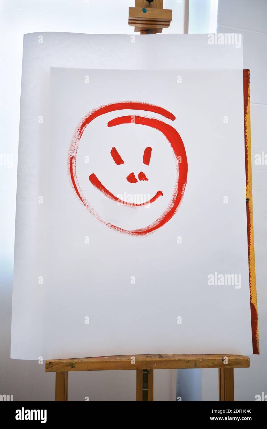 white paper with a painted smiling face on an easel, image with copy space Stock Photo