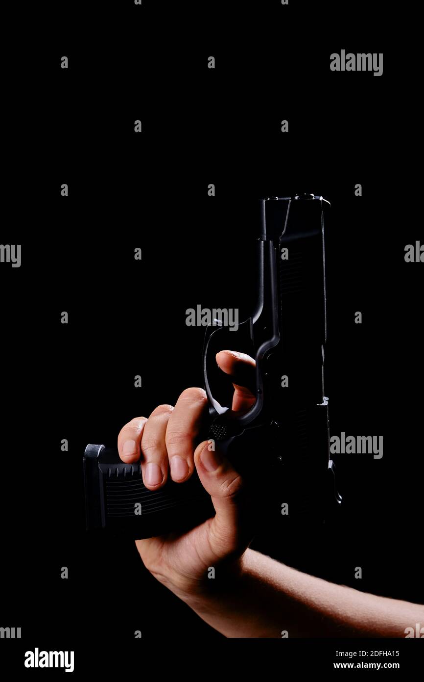 female hand with gun closeup on black background Stock Photo