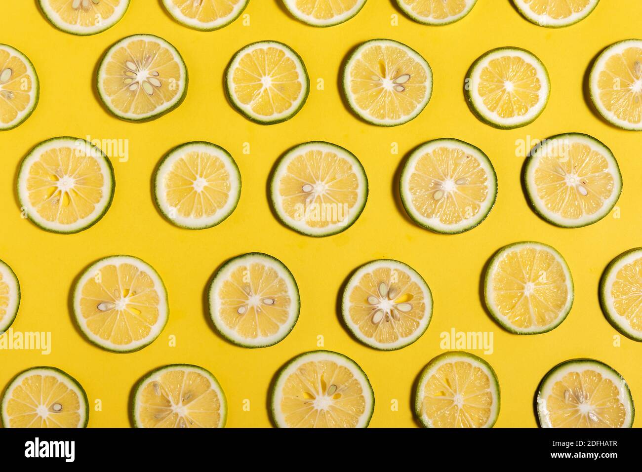 A top view closeup of lime slices on a yellow background Stock Photo ...