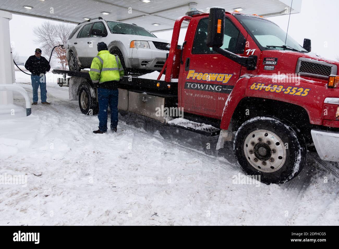 Tow truck bringing a car to the gas station to fill the gas tank New