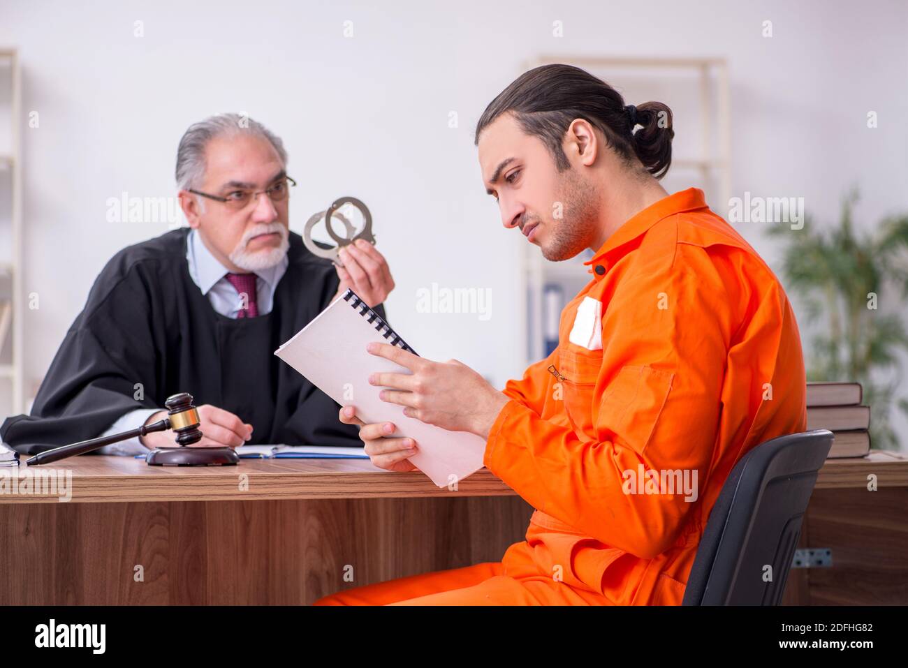 Old judge meeting with young captive in courthouse Stock Photo