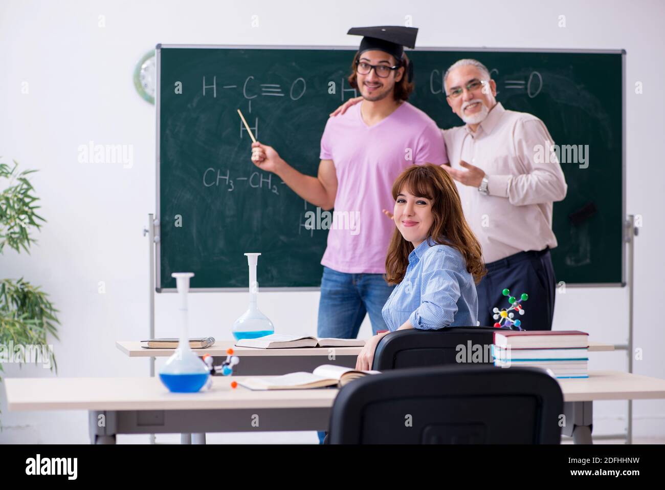 Old teacher and two students in the classroom Stock Photo - Alamy