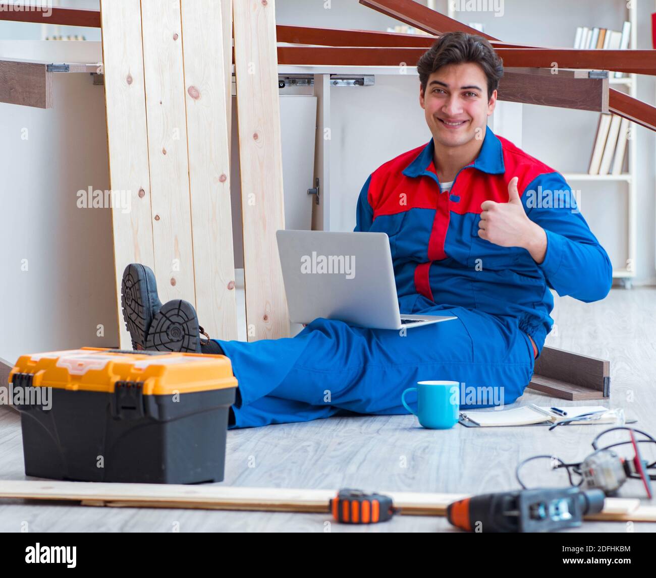 The young carpenter with a laptop computer Stock Photo - Alamy
