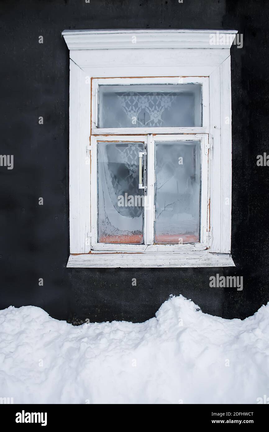The snowdrift under the frozen wooden window with thermometer of the ...