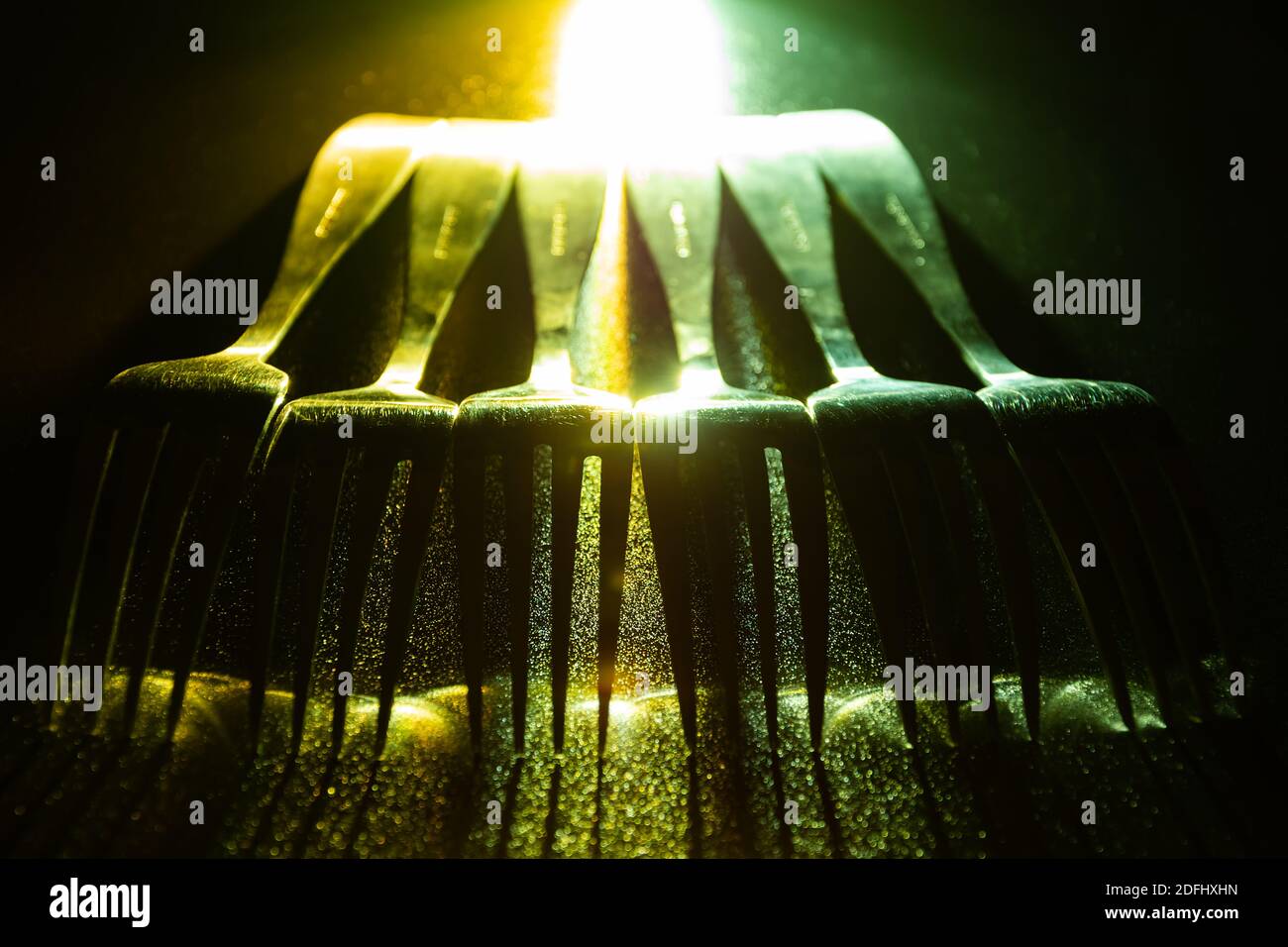 A set of forks in a raw with green and yellow contrast gradient led light. Stock Photo