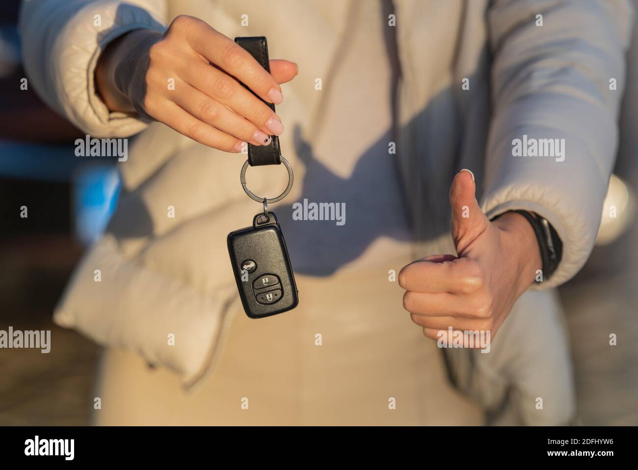 Woman holding key of her new car. Woman has got driving license and ready to drive Stock Photo