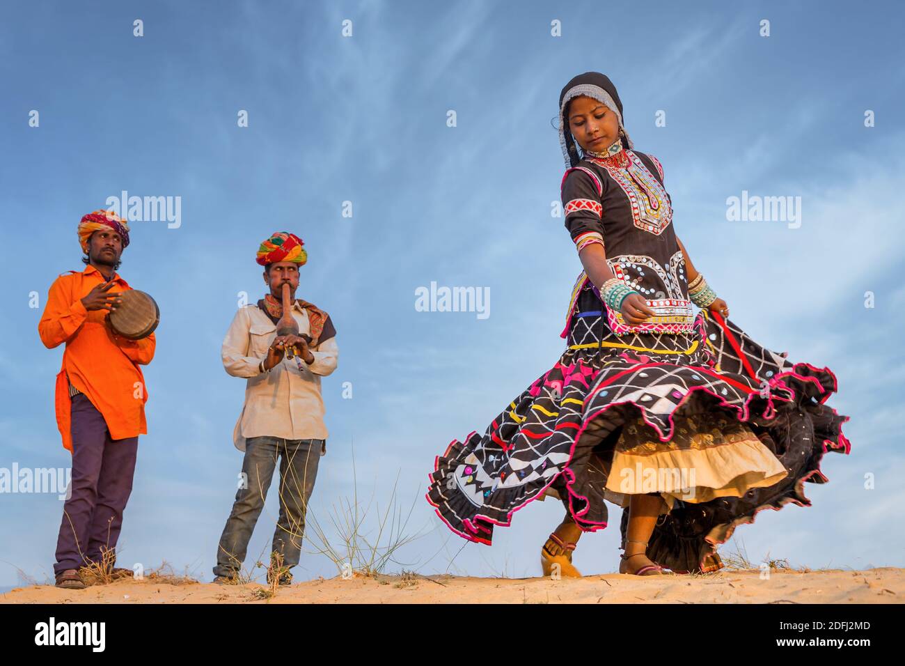 A gypsy woman dancing a traditional dance with two musicians, Pushkar, Rajasthan, India Stock Photo