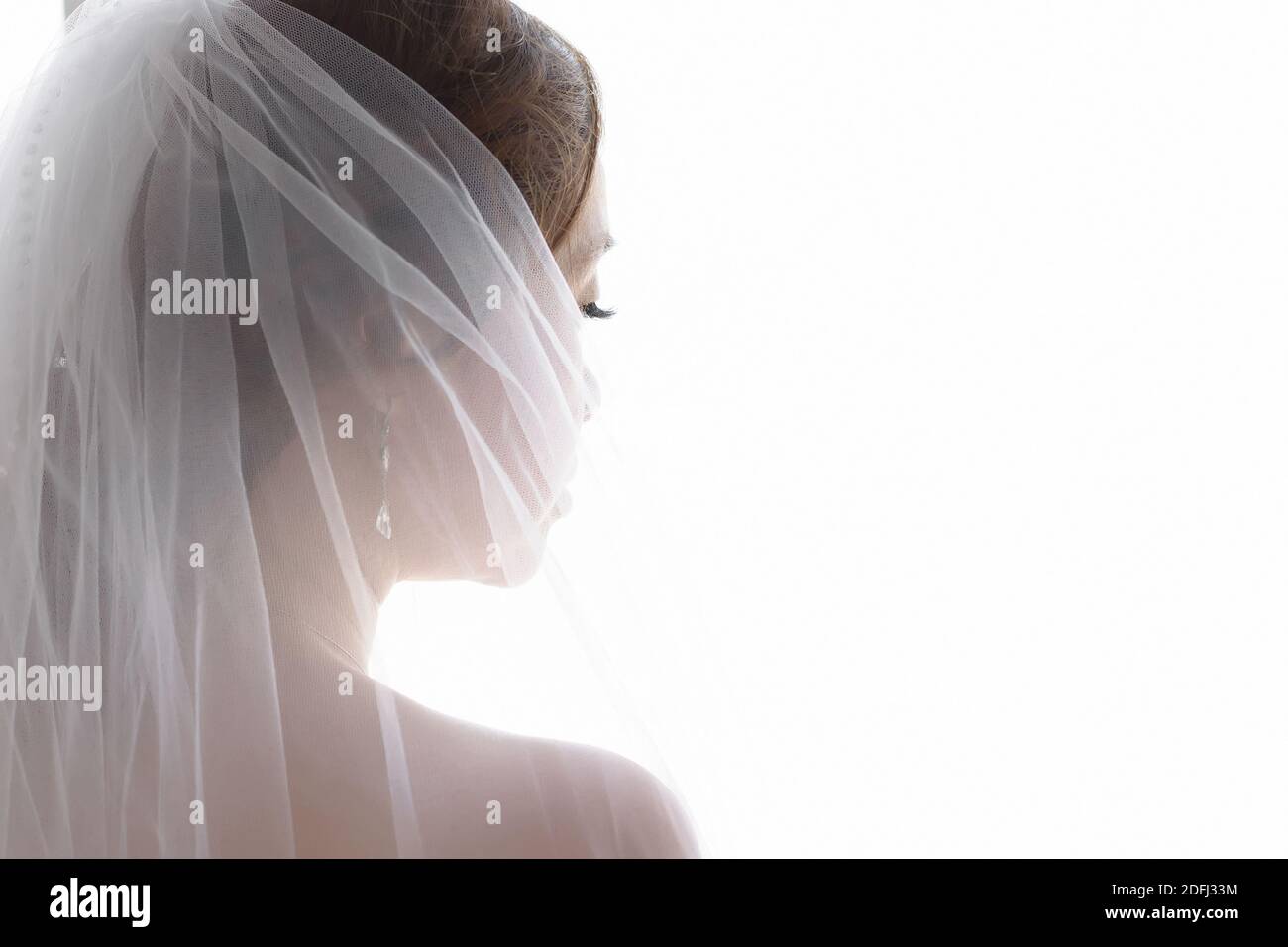 Silhouette of the bride from the back close-up, head and shoulders, on a white background. Space for text Stock Photo