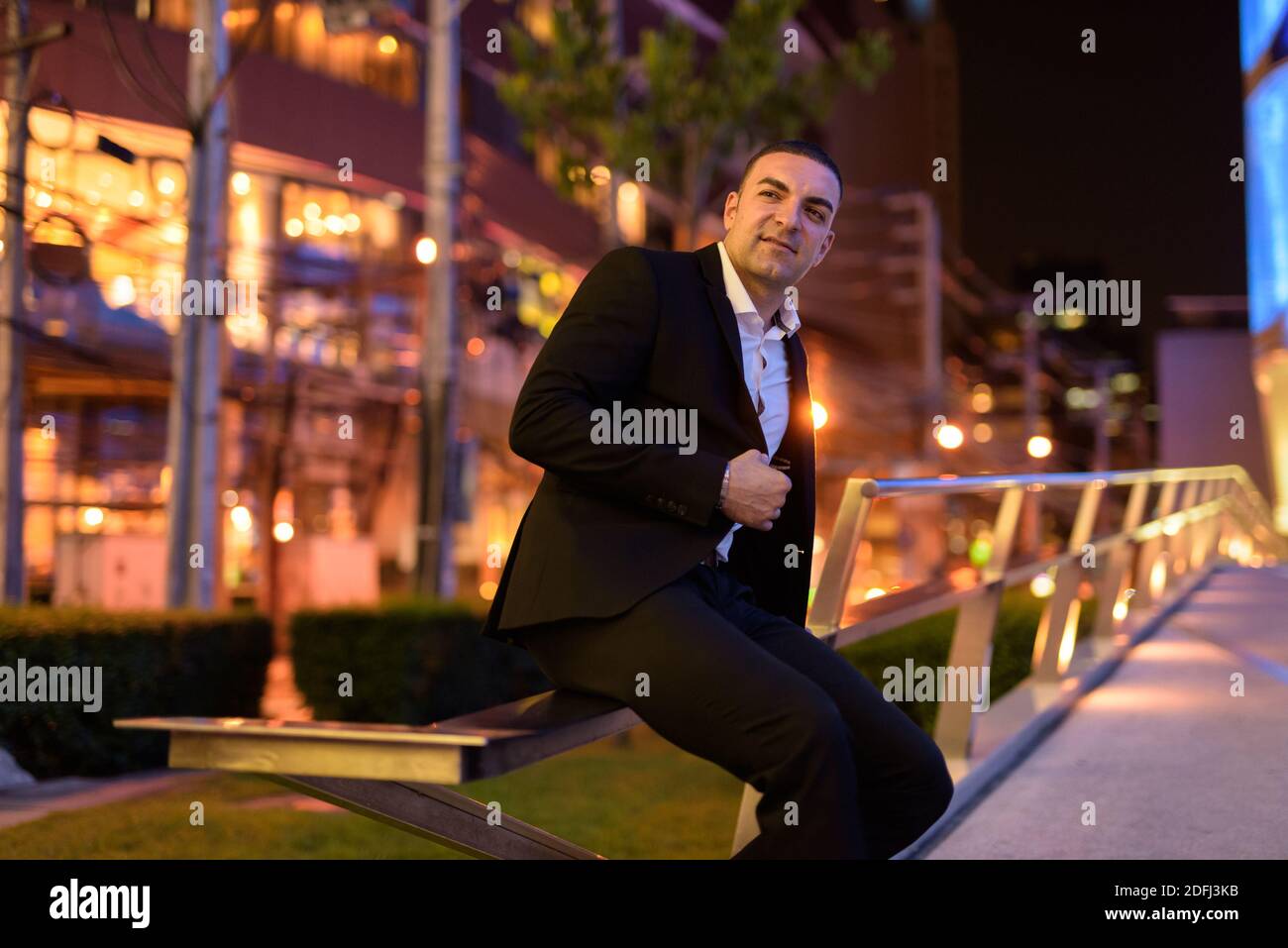 Portrait happy of businessman wearing suit outdoors at night in city ...