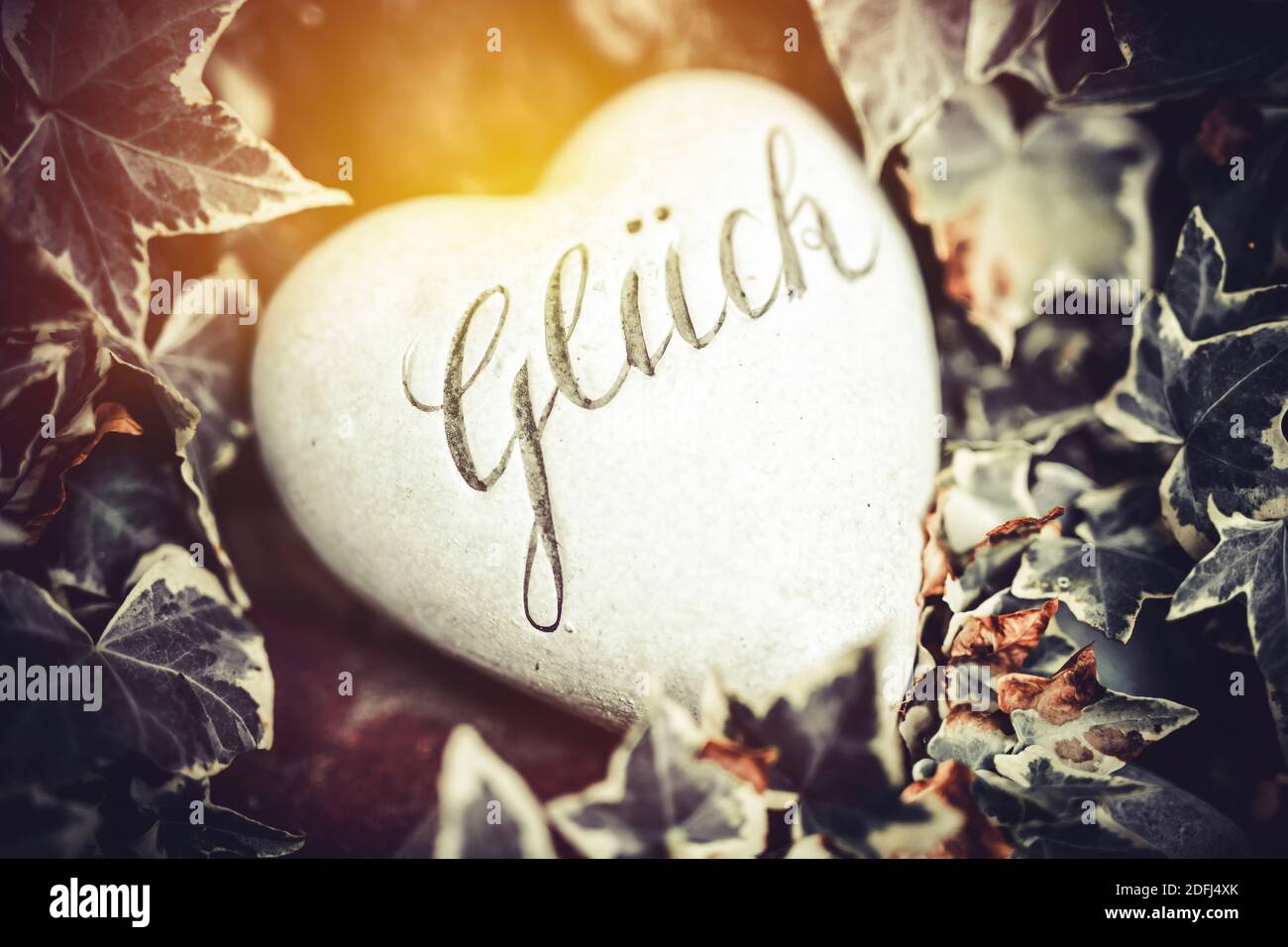 The German Word For Happiness On A Heart Shaped Stone Stock Photo