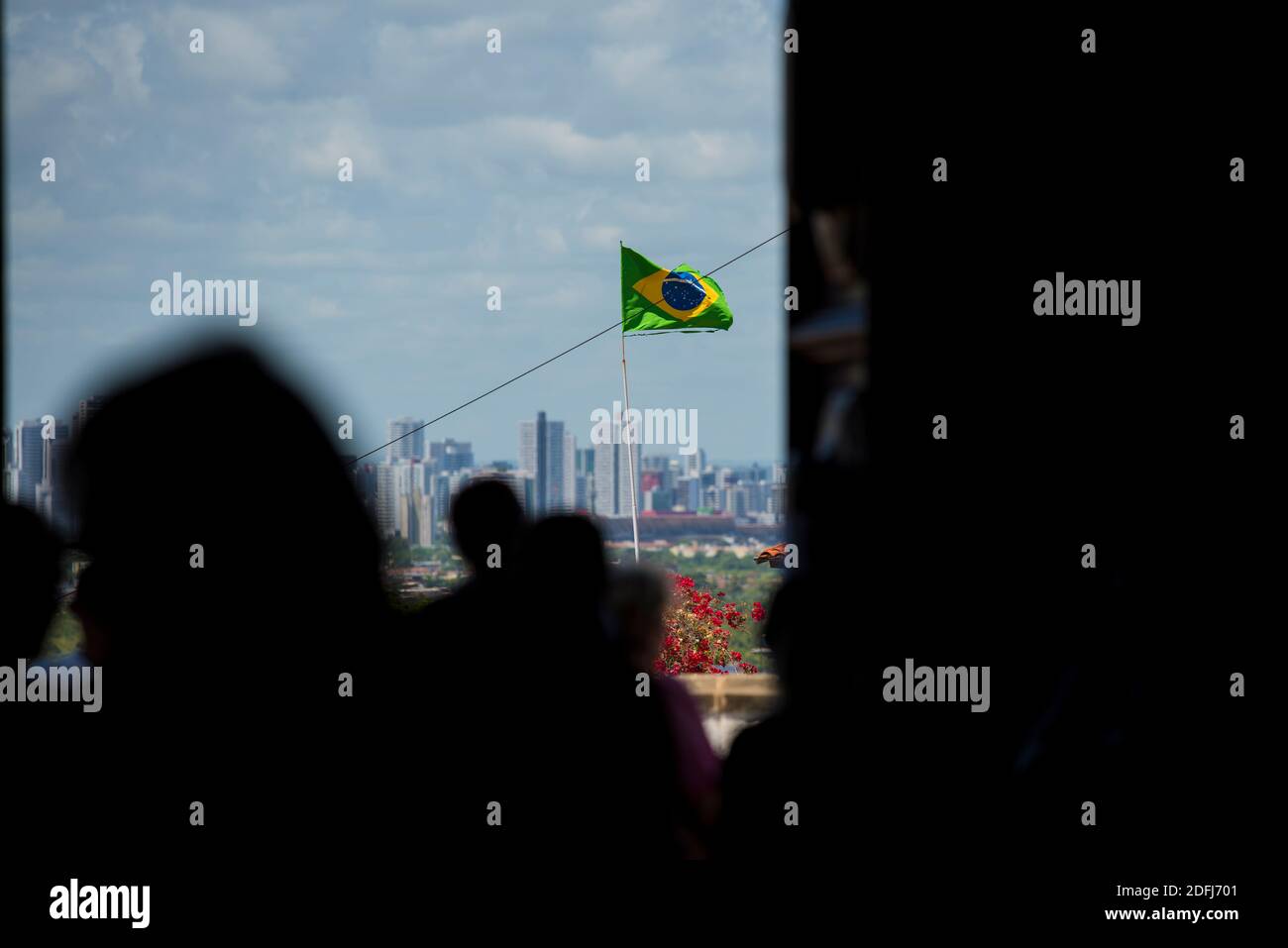 Brazilian flag on a flagpole waving in blue cloudy sky on a house in ...