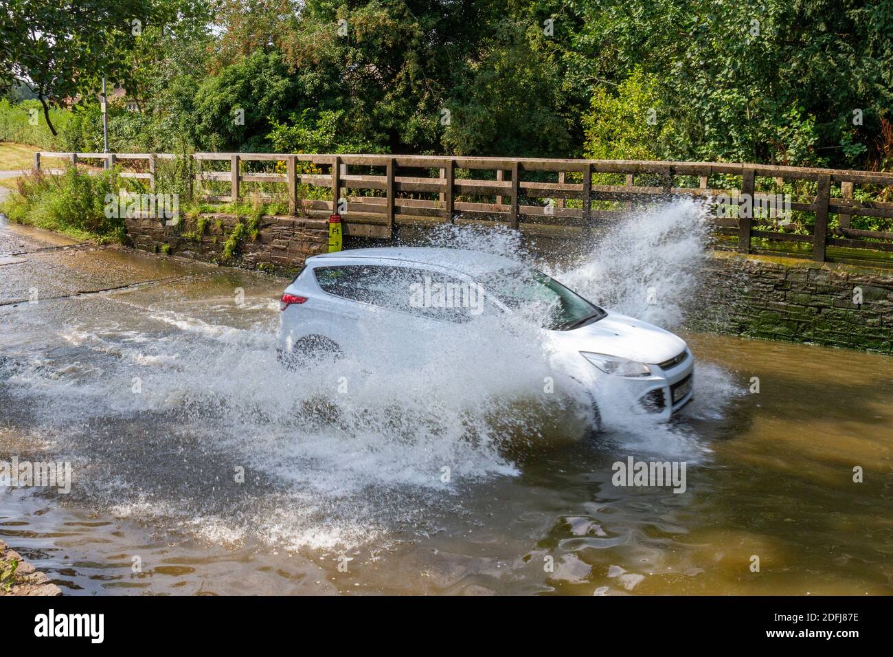 Car splashing through Rufford Ford, Rufford Lane, Rufford Country Park, Nottinghamshire, UK. Stock Photo