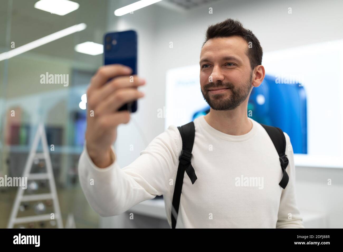 Belarus; December 05, 2020; a young man in an Apple store testing the camera of the new phone Apple 12 pro max Stock Photo