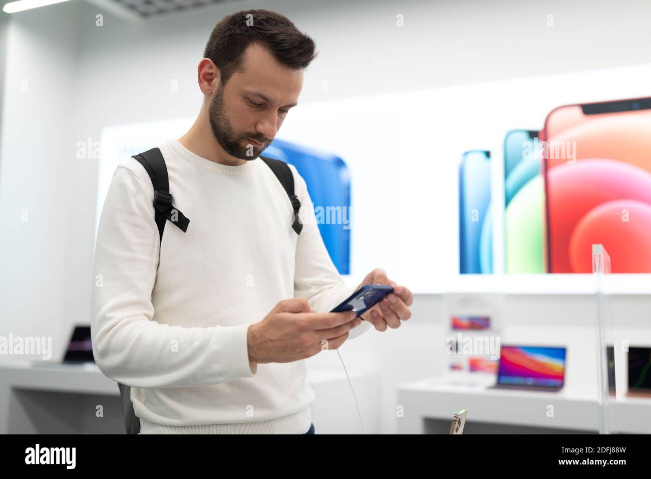 Belarus; December 05, 2020; a man buys an iPhone 12, chooses a gift in an epl brand salon, a modern smartphone with three cameras and a touch screen Stock Photo
