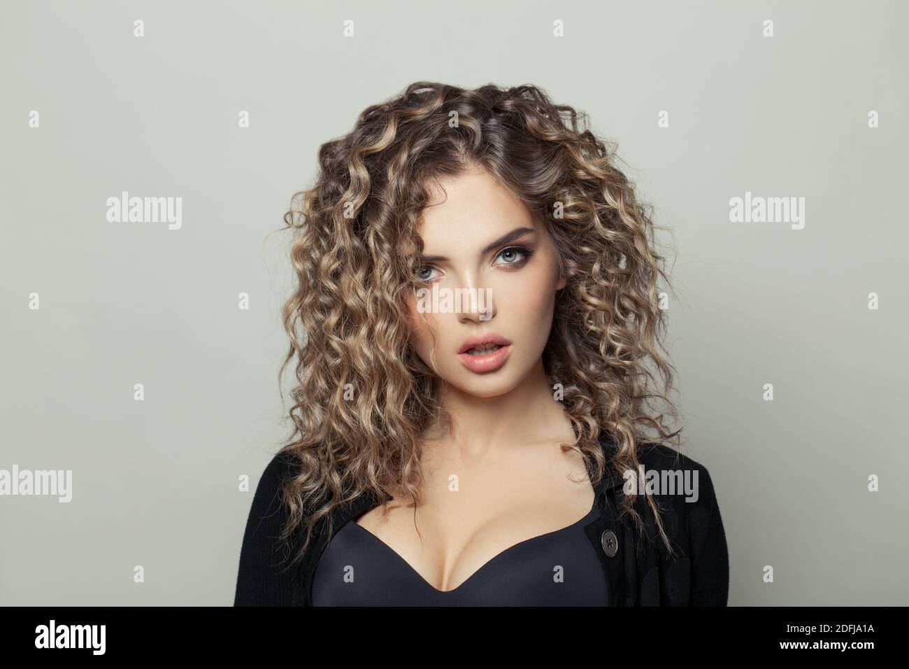 Pretty woman with curly hair on white background Stock Photo - Alamy