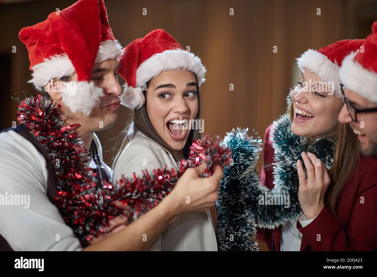 A group of excited colleagues yelling and posing for a photo at New Year celebration in the hallway in a holiday atmosphere at workplace. Together, Ne Stock Photo