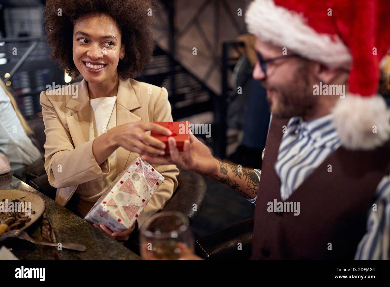 multiethnic couple having dinner, exchanging presents. new year celebration concept Stock Photo