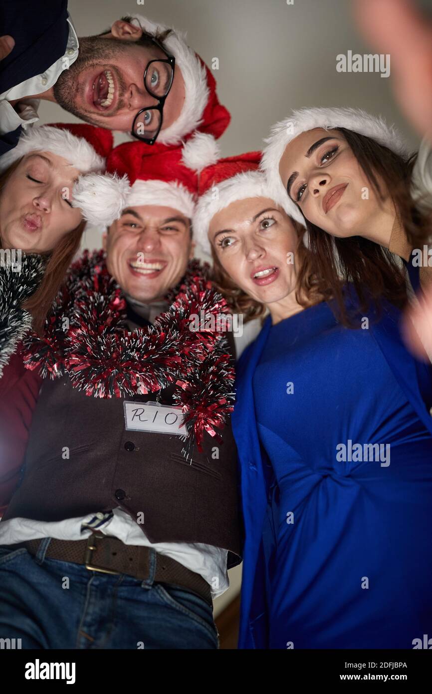 A group of colleagues making funny photos at the New Year celebration at the workplace in a cheerful atmosphere. Together, New Year, celebration Stock Photo