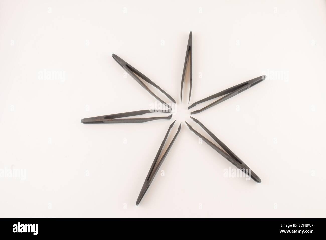Black star made up of six pairs of black tweezers isolated on a white background Stock Photo