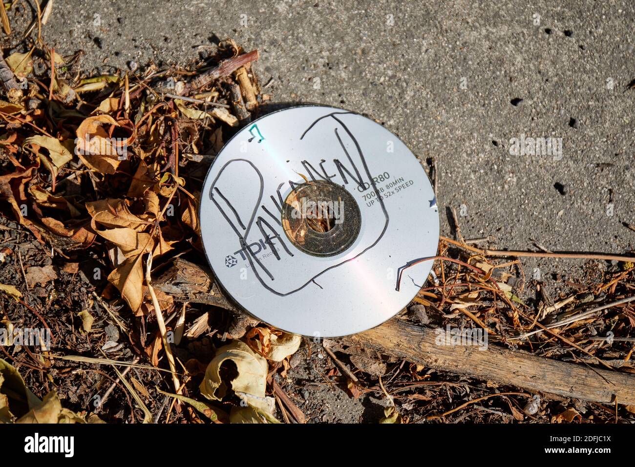 Discarded CDR in gutter, labelled 'Pavement' with black marker Stock Photo