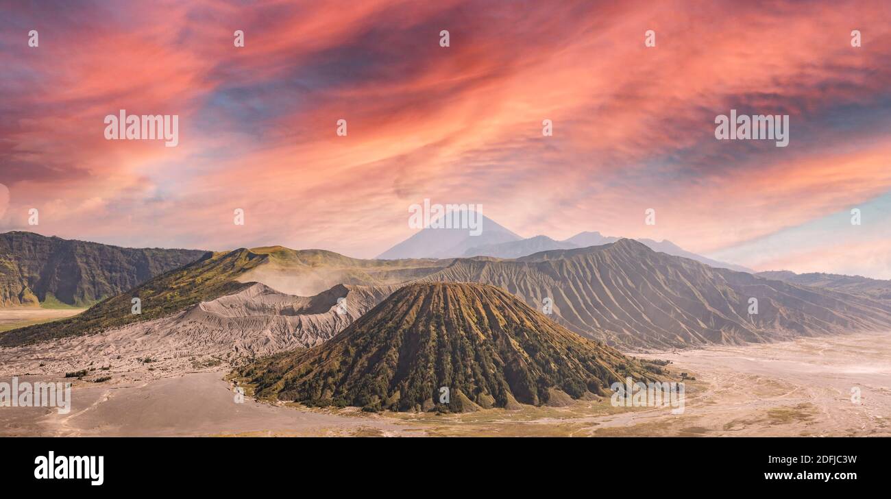 View from above, stunning aerial view of the Mt. Bromo and Mt Batok in the foreground and Mt Semeru in the distance during a dramatic sunset. Stock Photo