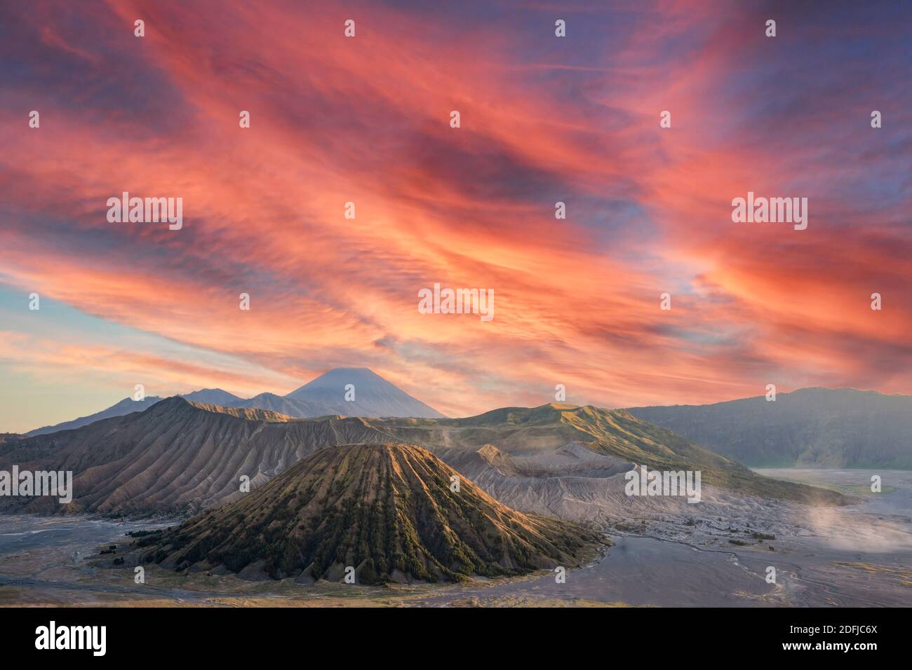 View from above, stunning aerial view of the Mt. Bromo and Mt Batok in the foreground and Mt Semeru in the distance during a dramatic sunset. Stock Photo