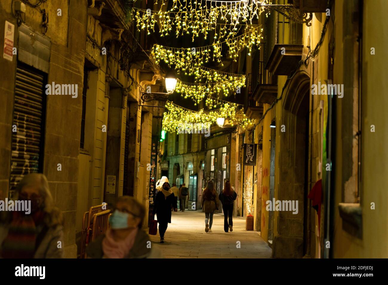 barcelona, spain - 3 december 2020: christmas time in barcelona. people walk in the city center at night doing christmas shopping with christmas light Stock Photo