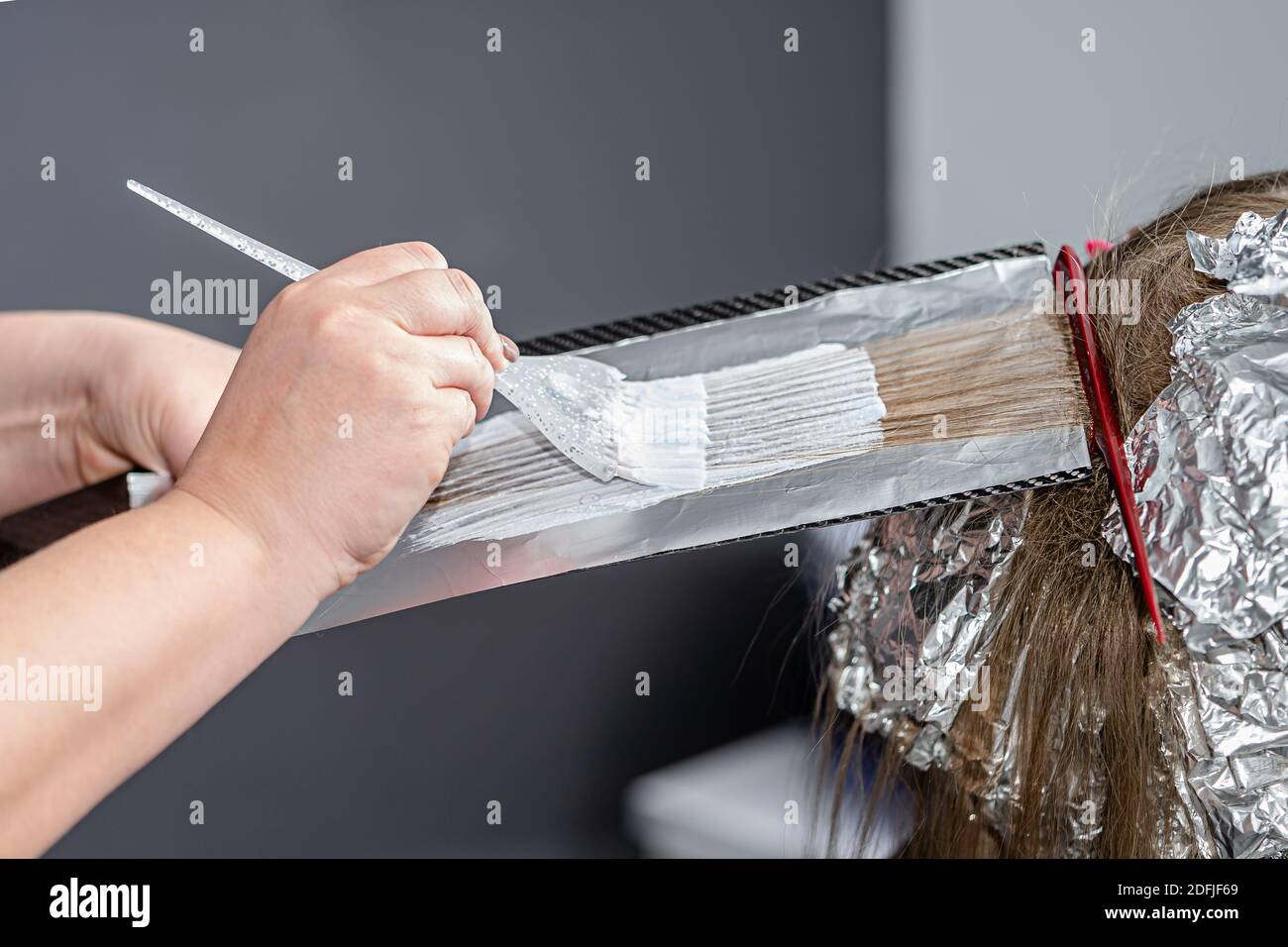 Process of applying bleaching powder on clients hair and wrapping into