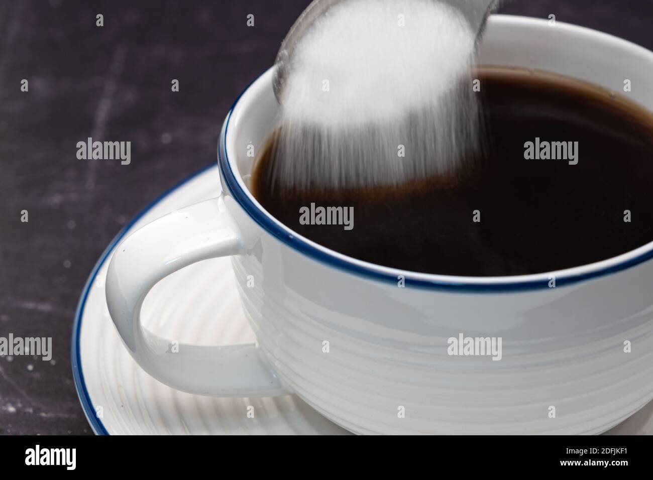 A teaspoon adding sugar to a hot drink Stock Photo