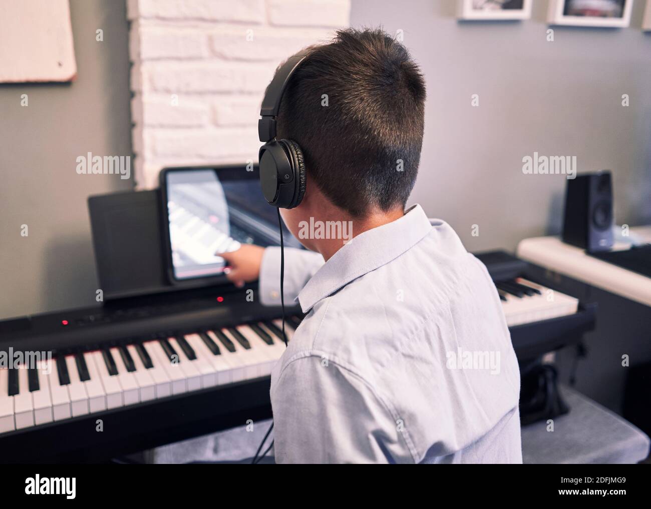 Child learning piano online lessons in quarantine . Coronavirus life style Stock Photo